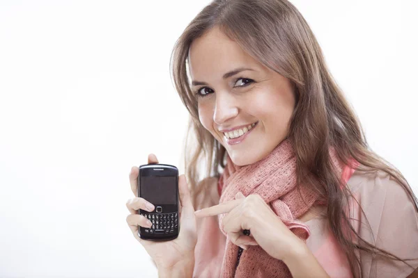 Carina giovane donna indica un telefono cellulare — Foto Stock