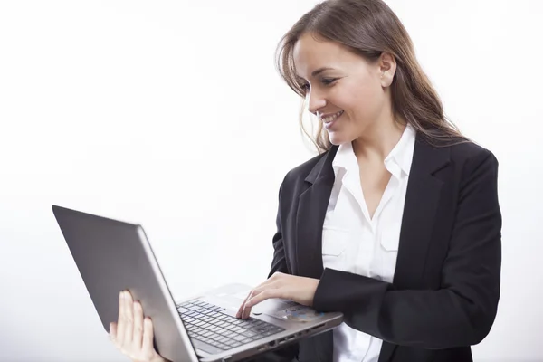 Portrait of a young happy business woman with a laptop over white background — Stock Photo, Image