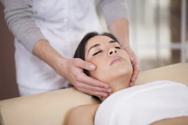 Mooie jonge ontspannen vrouw gezicht massage ontvangen — Stockfoto