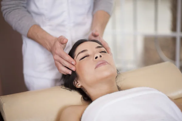 Mooie jonge ontspannen vrouw gezicht massage ontvangen — Stockfoto