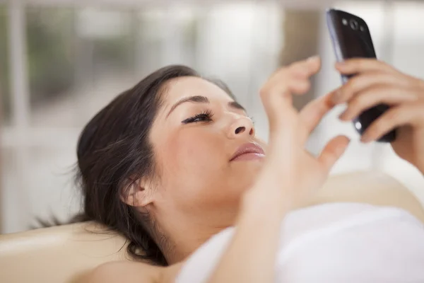 Woman typing message on her mobile while having massage — Stock Photo, Image