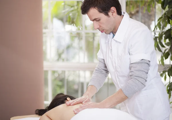 Terapeuta bonito faz massagem para seu paciente — Fotografia de Stock