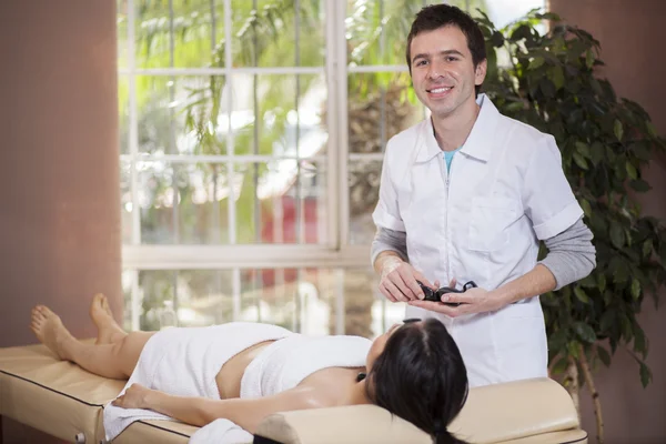 Thérapeute faire un massage aux pierres chaudes à son patient — Photo