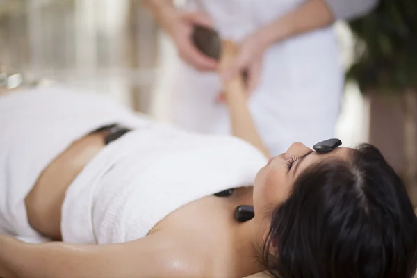 Bella donna godendo di un massaggio di pietra calda — Foto Stock