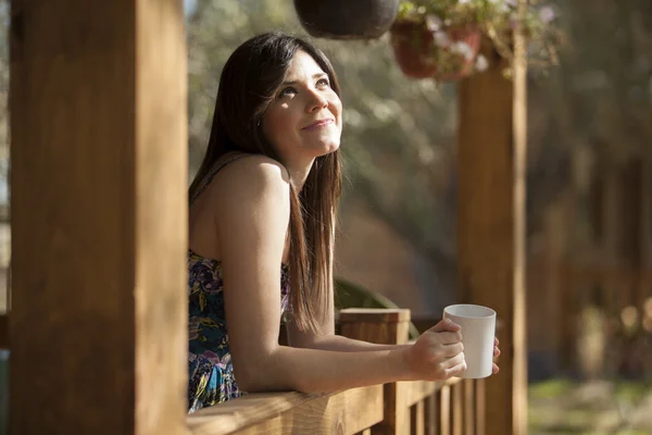 Girl drinking tea on veranda — Stock fotografie