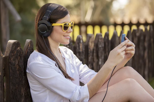 Девушка в солнечных очках слушает музыку — стоковое фото