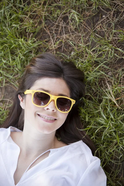 Beautiful woman lying on the green grass — Stock Photo, Image