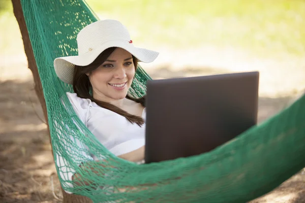 Girl with a laptop in a hammock — Stock Photo, Image