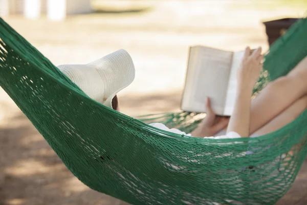 Fille lisant un livre dans un hamac — Photo