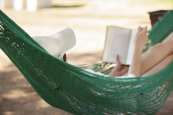 Mädchen liest ein Buch in einer Hängematte — Stockfoto