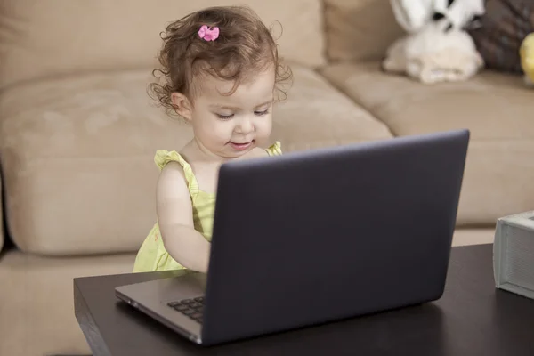 Klein schattig kind spelen met laptop thuis — Stockfoto