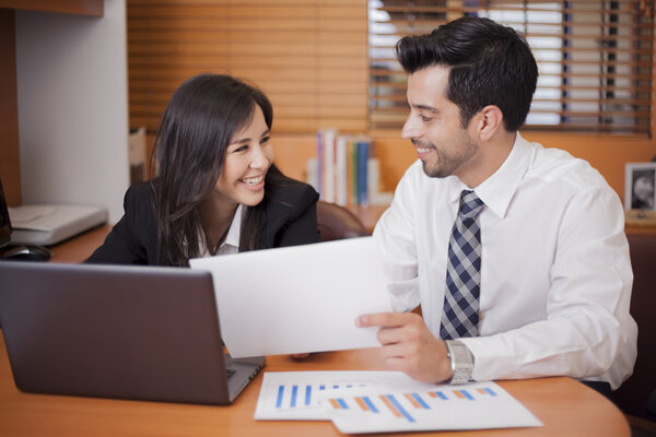 Businessman and businesswoman sitting at desk at work