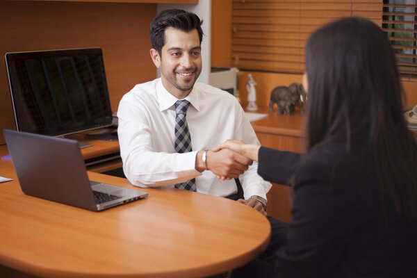 Businessman shaking hands with a Businesswoman in an office