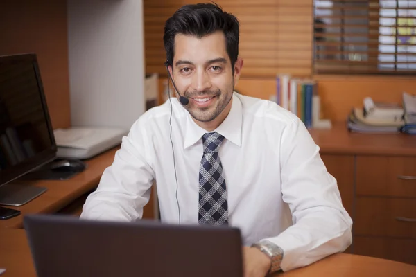 Portrait of a happy successful mature business man talking on the microphone in the headphones — Stock Photo, Image