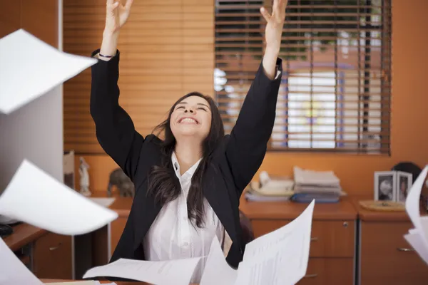 Jonge vrouw en vliegende papers in office Rechtenvrije Stockfoto's