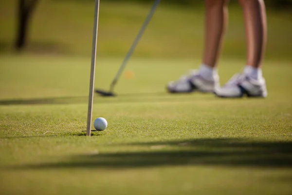 Kvinnans ben, Golf på gröna, kvinna sätter bollen — Stockfoto