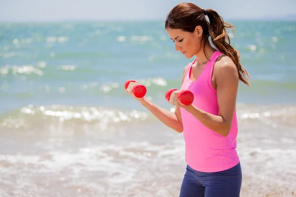 Jong meisje doen oefeningen met dumbells — Stockfoto