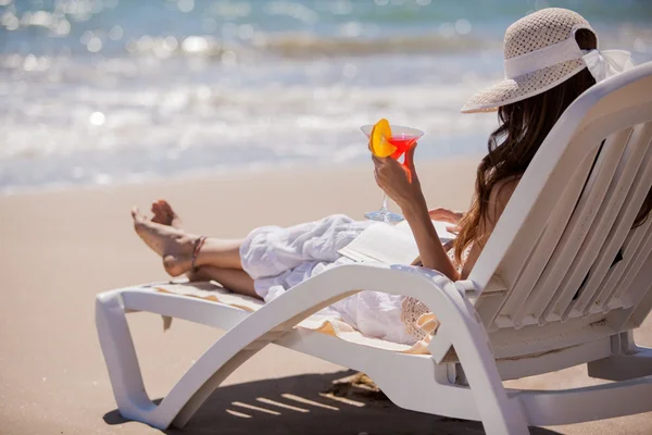 Beautiful woman reading a book on beach — Stock Photo, Image