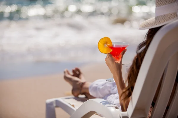 Vacker kvinna läser en bok på stranden — Stockfoto