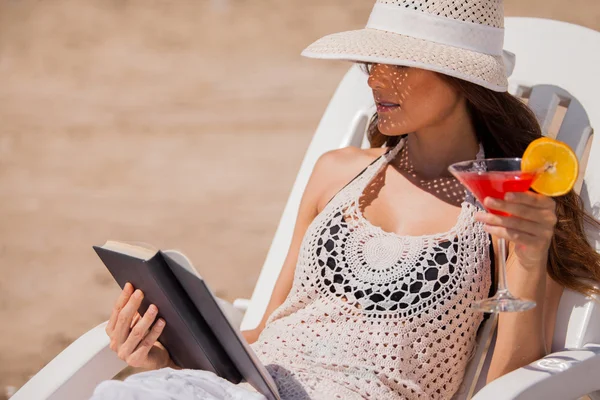 Hermosa mujer leyendo un libro en la playa — Foto de Stock