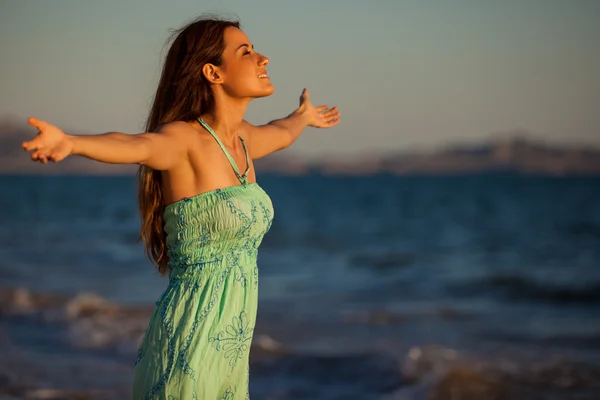 Młoda kobieta na plaży o zachodzie słońca — Zdjęcie stockowe