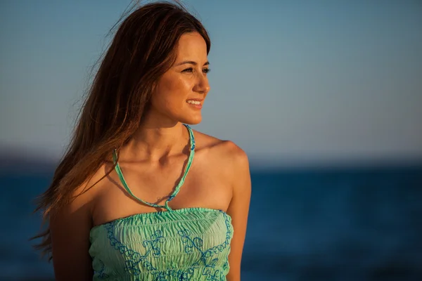 Jeune femme sur la plage au coucher du soleil — Photo