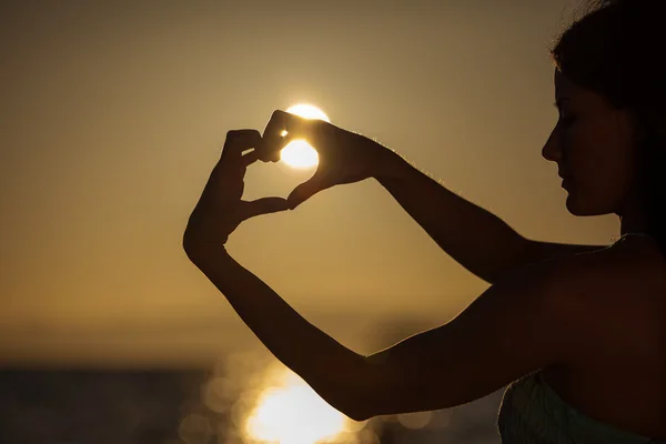Jovem mulher na praia ao pôr do sol — Fotografia de Stock