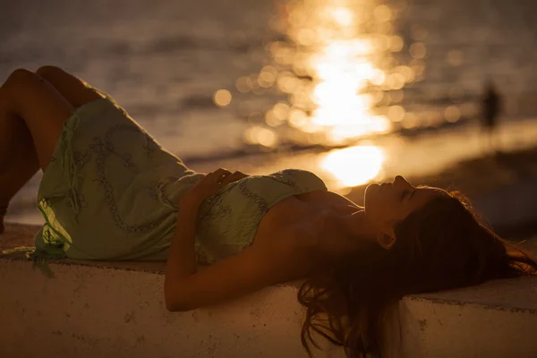 Young woman on the beach at sunset — Stock Photo, Image