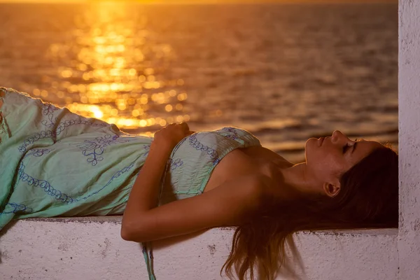 Young woman on the beach at sunset — Stock Photo, Image