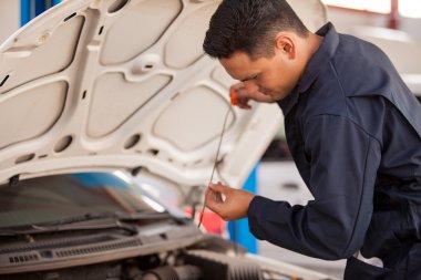 mekanik motor yağı kontrol eder.
