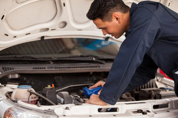 Ein Mechaniker überprüft das Öl im Motor — Stockfoto