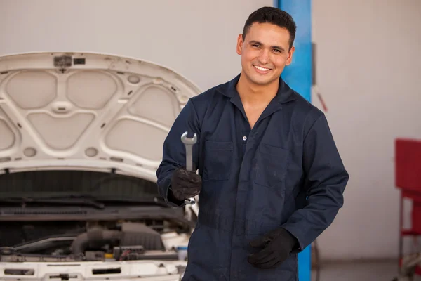 Mechanic holding a wrench at a car garage — Stock Photo, Image