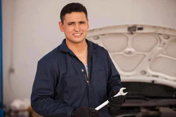 Mechaniker mit einem Schraubenschlüssel in einer Autowerkstatt — Stockfoto