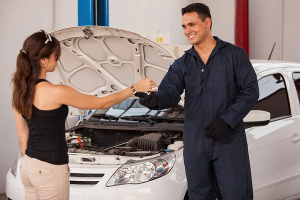 Mechaniker steht neben einem Kunden in einer Garage — Stockfoto