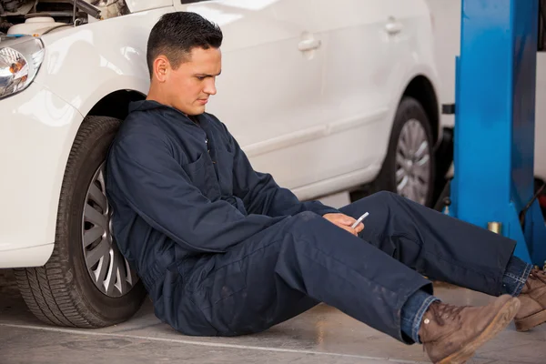 Der Mechaniker ruht sich in der Nähe des Autos aus — Stockfoto