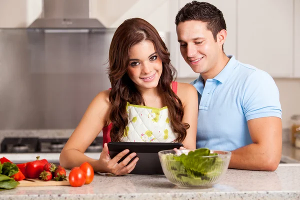Пара ищет ужин рецепт в планшетном компьютере — стоковое фото