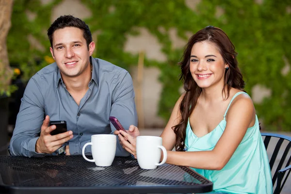 Casal usando seus telefones celulares em um encontro — Fotografia de Stock