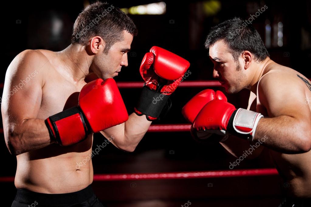 Two young boxers facing each other in a match — Stock Photo © tonodiaz