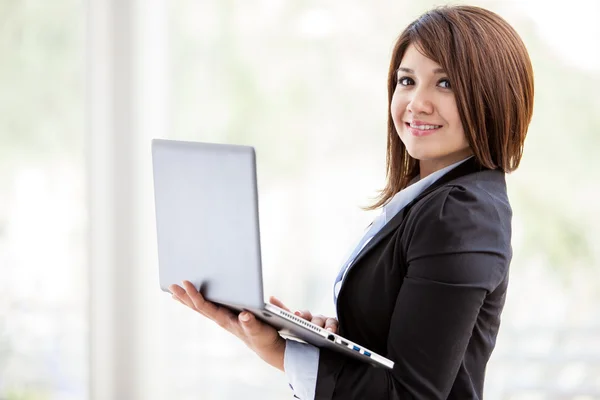 Retrato de uma jovem mulher de negócios feliz com um laptop — Fotografia de Stock