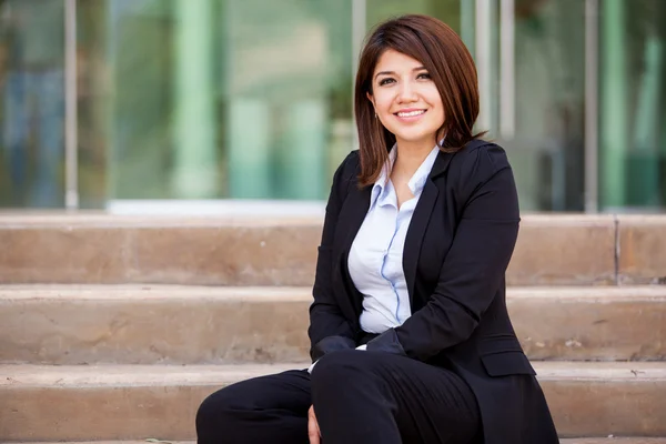 Jovem mulher de negócios sorridente sentada na escada — Fotografia de Stock