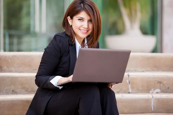 Dizüstü bilgisayar kullanan iş kadını gülümseyen — Stok fotoğraf