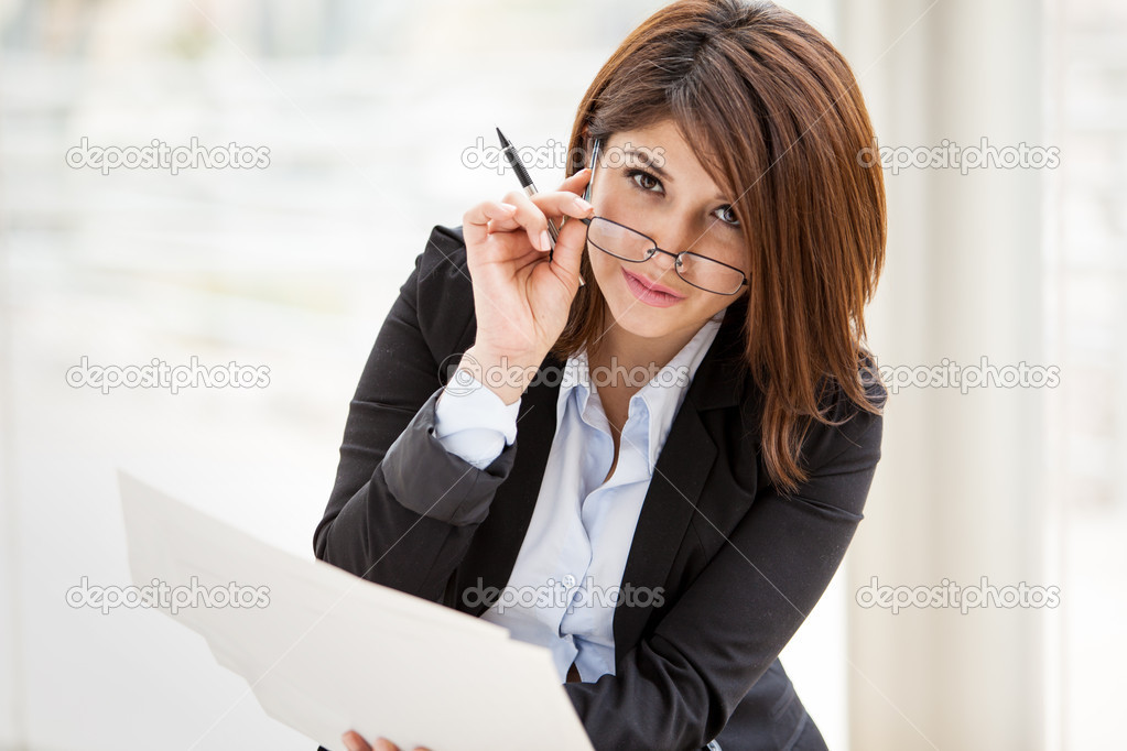 Beautiful business woman stares forward and holding documents