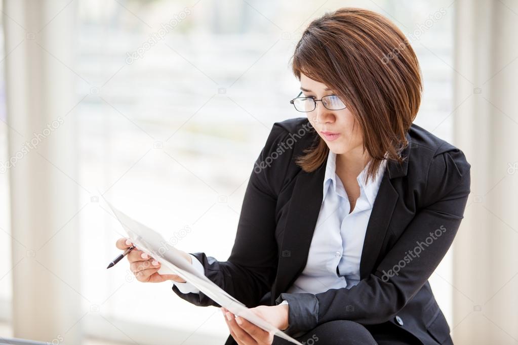 Beautiful business woman carefully read the documents