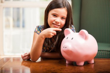 Little girl with a piggy-bank clipart