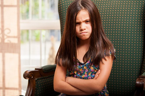 Triste menina sentada na poltrona — Fotografia de Stock