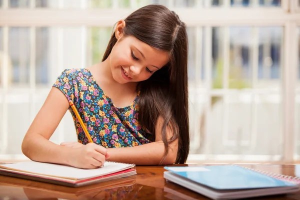 En liten flicka gör sina läxor — Stockfoto