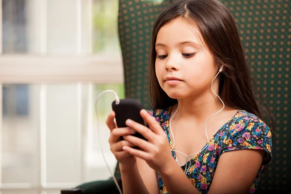 Kis lány hallgat zenét a telefonon — Stock Fotó