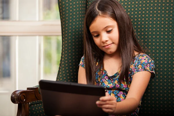 Meisje met behulp van tablet-pc in leunstoel — Stockfoto