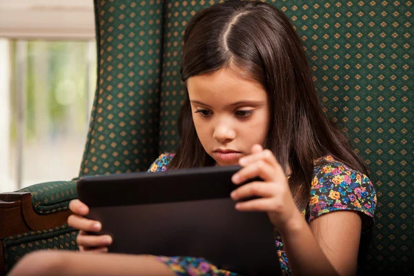 Meisje met behulp van tablet-pc in leunstoel — Stockfoto