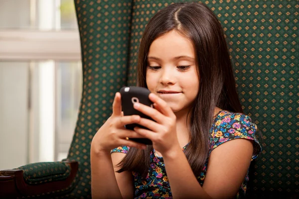 Linda niña sosteniendo el teléfono celular — Foto de Stock